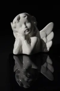 A white porcelain angel figurine on black