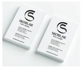 Two stacks of white business cards with the monogram and studio name